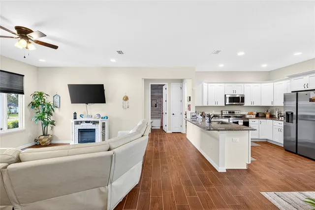 a living room with furniture a flat screen tv and a fireplace