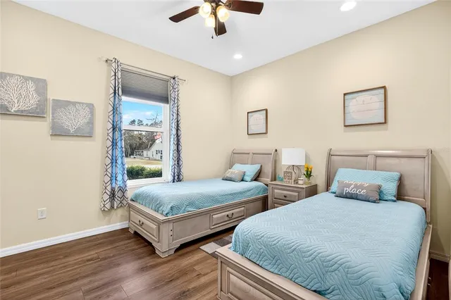 a bedroom with two beds and painting on the wall