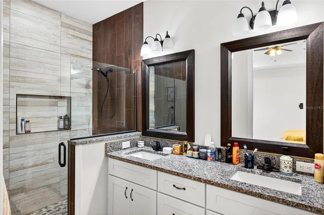 a bathroom with double vanity and a mirror