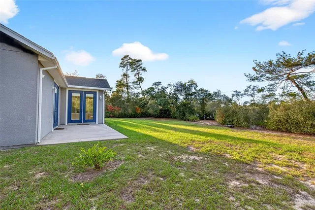 a view of a house with a yard and basketball court