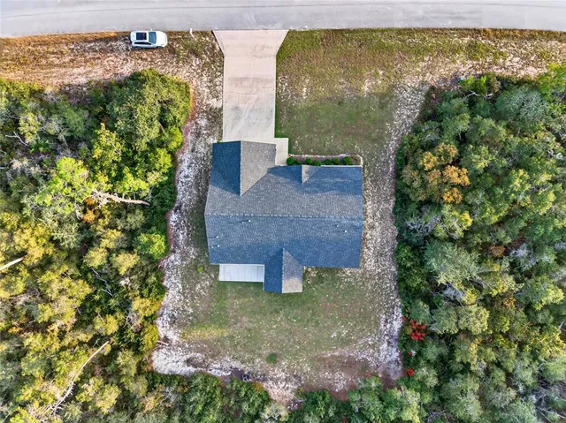 an aerial view of a house with a yard basket ball court and outdoor seating