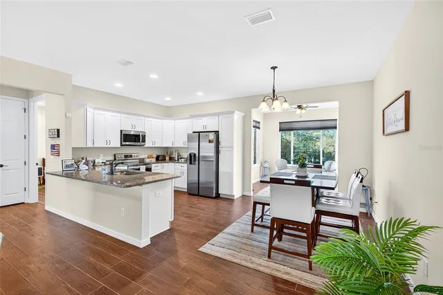 a kitchen with stainless steel appliances kitchen island granite countertop a stove and a refrigerator