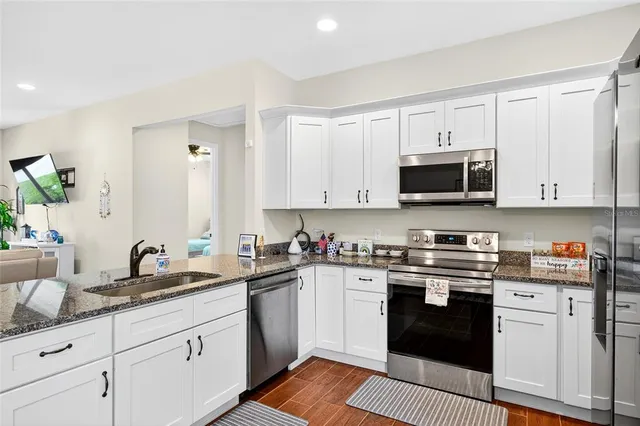 a kitchen with stainless steel appliances granite countertop a sink and cabinets