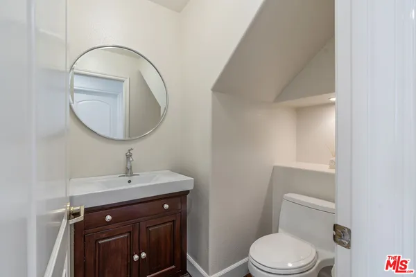 a bathroom with a sink a toilet and a mirror