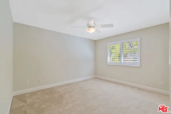 a view of an empty room with a ceiling fan