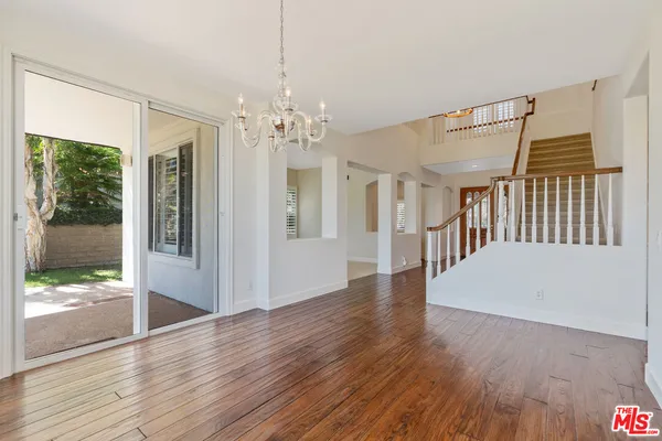 a view of a livingroom with wooden floor and windows