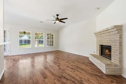 a view of empty room with wooden floor and fireplace