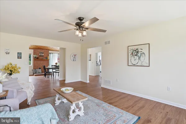 a dining room with furniture a floor to ceiling window and wooden floor