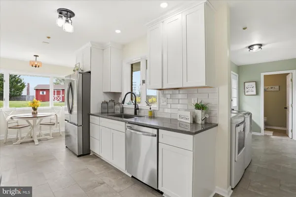 a kitchen with stainless steel appliances granite countertop a sink stove and cabinets