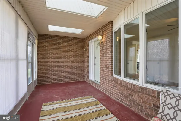 a view of a patio with table and chairs and wooden floor