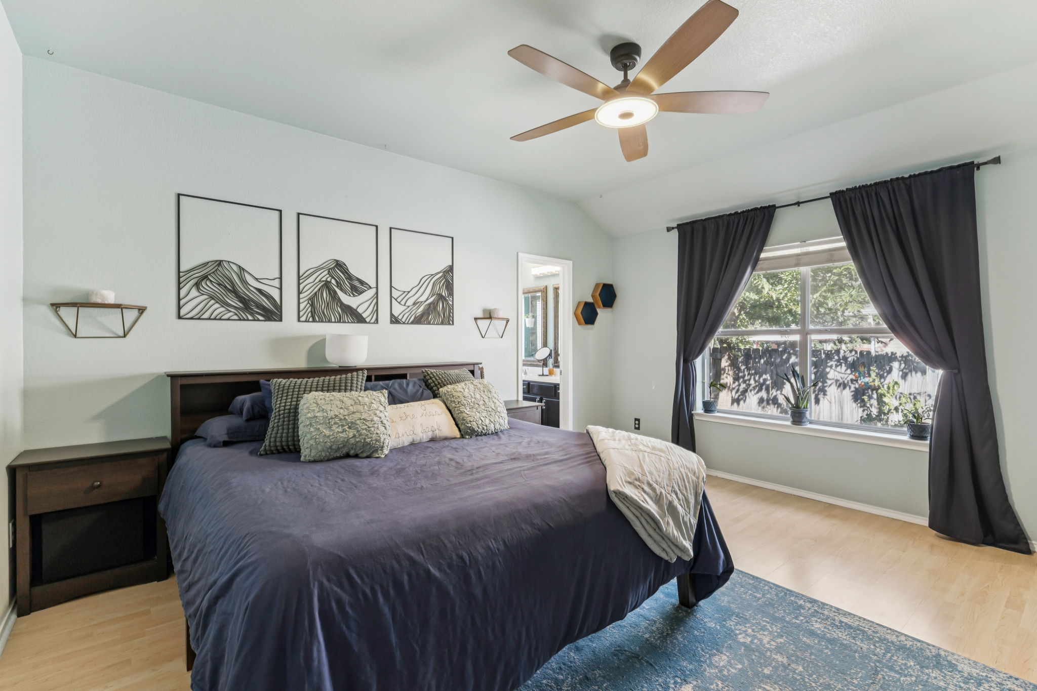 2412 Chestnut Path Round Rock, TX 78664 - Photo 11 of 26 Hard floors and a vaulted ceiling elevate this primary bedroom suite with an ensuite bathroom.