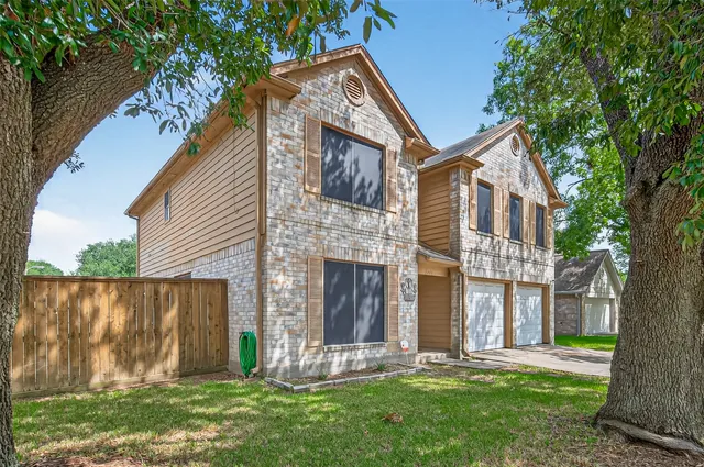 a front view of a house with a garden and yard
