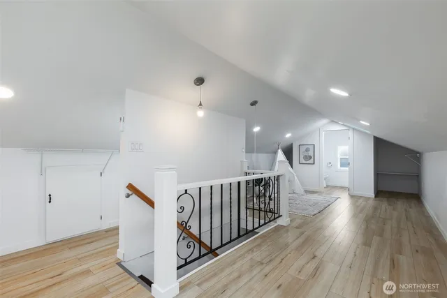 a view of a hallway with wooden floor and staircase