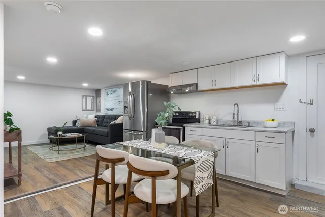 a kitchen with kitchen island white cabinets and stainless steel appliances