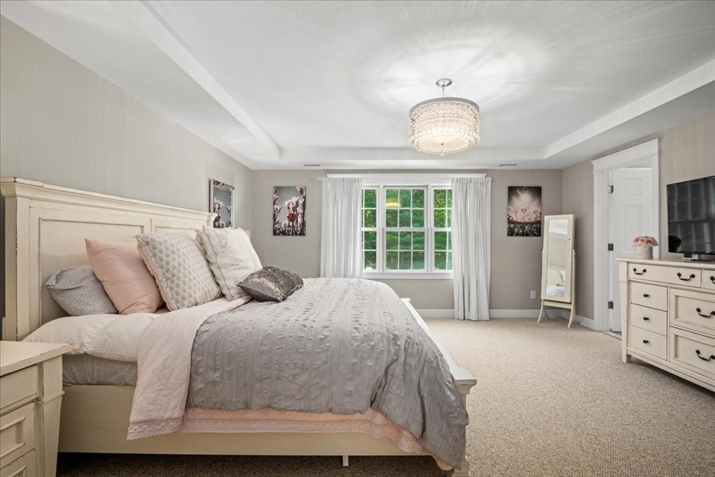 9 Auburn Road Millbury, MA 01527 - Photo 20 of 42 a spacious bedroom with a bed and a chandelier