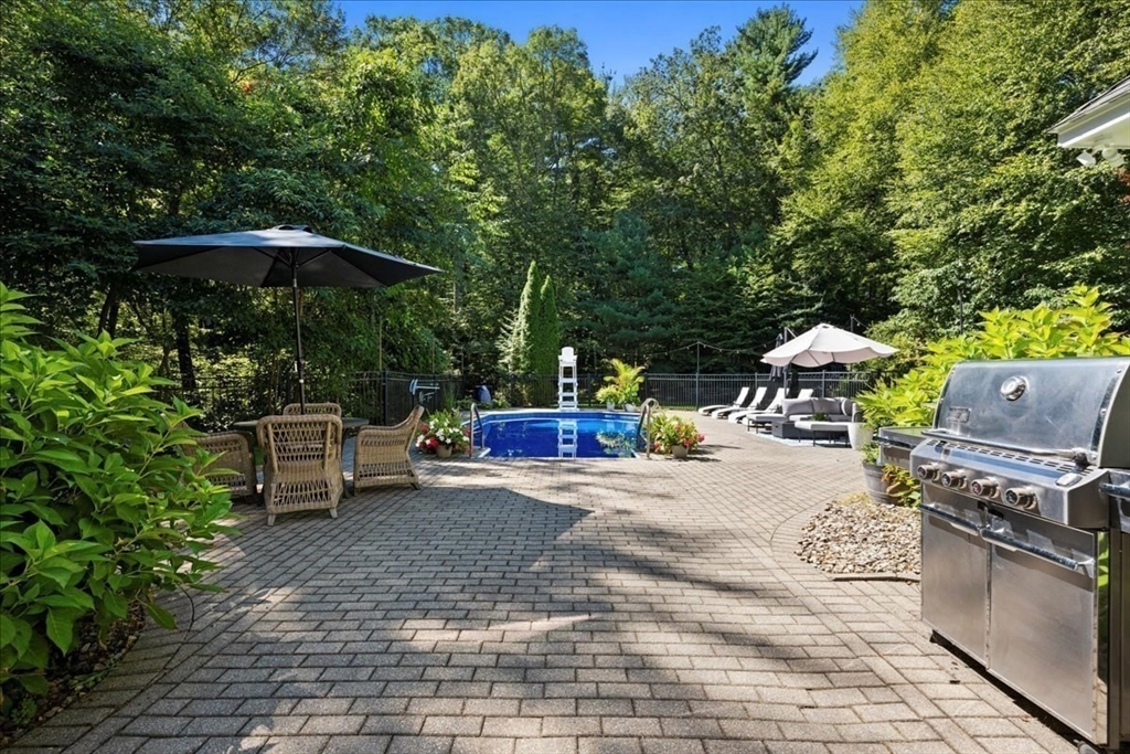 9 Auburn Road Millbury, MA 01527 - Photo 34 of 42 a view of a patio with a table and chairs under an umbrella