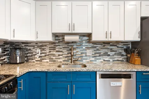 a kitchen with granite countertop a sink and a stove top oven