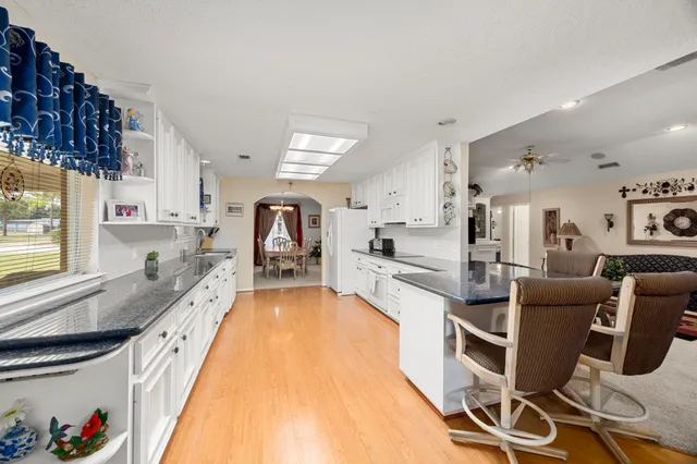 a large kitchen with stainless steel appliances lots of counter space and windows