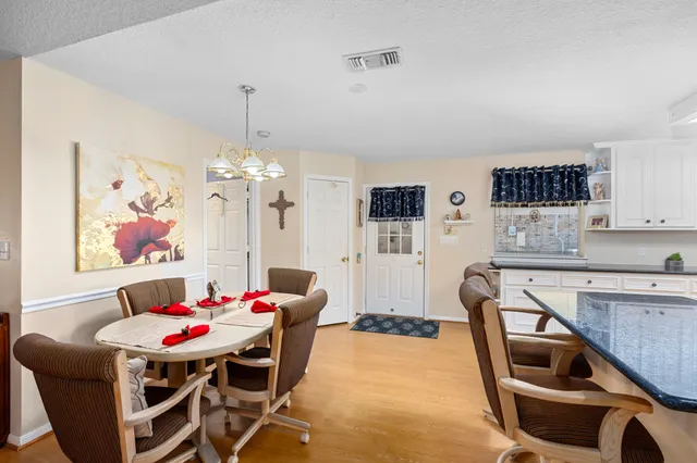 a view of a dining room with furniture and chandelier