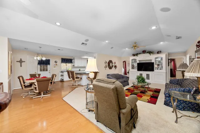 a living room with furniture kitchen view and a flat screen tv