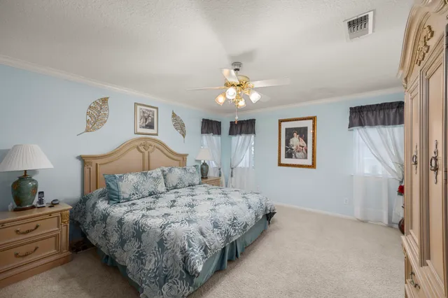 a bedroom with a large bed and a chandelier