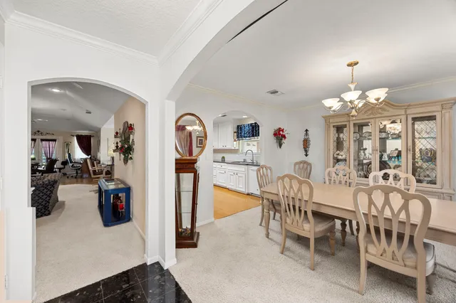 a view of a dining room with furniture and chandelier