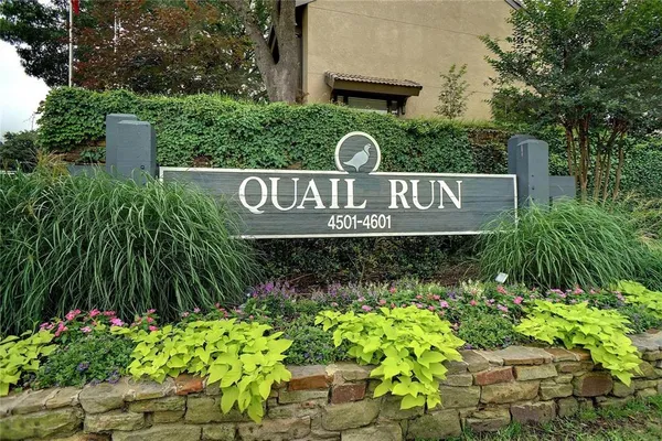 a sign that is sitting in front of flowers
