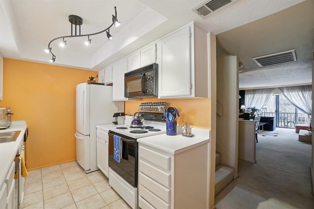 4569 North O'Connor Road, Unit 1319 Irving, TX 75062 - Photo 13 of 40 a kitchen with a refrigerator a stove top oven a sink and dishwasher