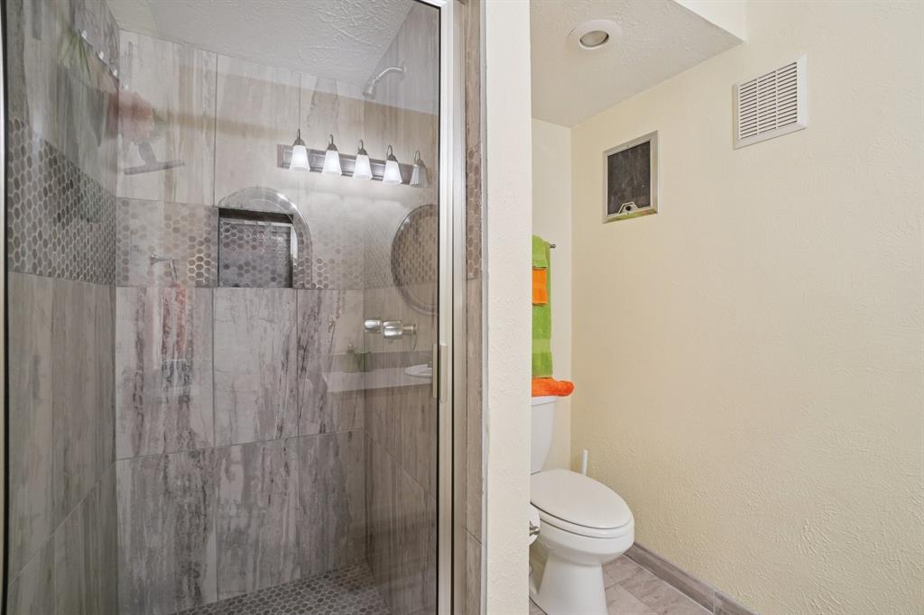 4569 North O'Connor Road, Unit 1319 Irving, TX 75062 - Photo 32 of 40 a white toilet sitting next to a bathroom sink and a shower