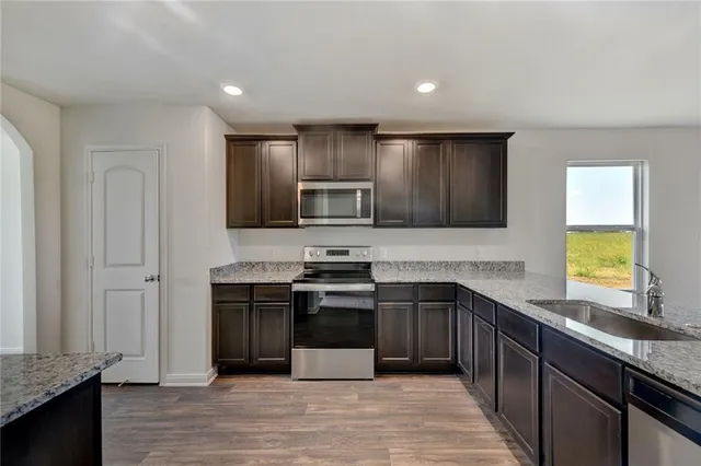 a kitchen with stainless steel appliances granite countertop a stove and a sink