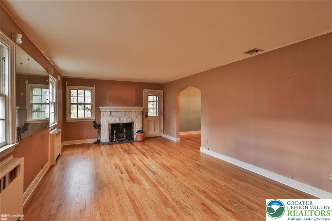 1104 Raymond Avenue Bethlehem, PA 18018 - Photo 7 of 67 a view of a livingroom with wooden floor a fireplace and windows