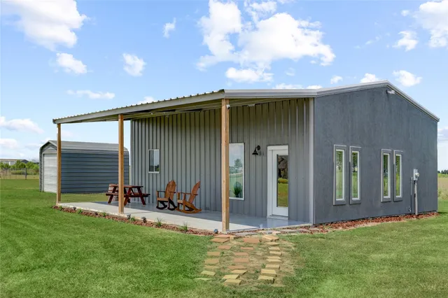 a backyard of a house with table and chairs