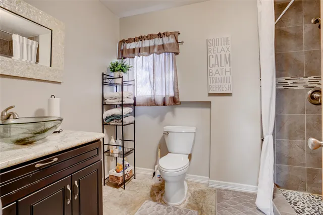 a bathroom with a toilet a sink and shower