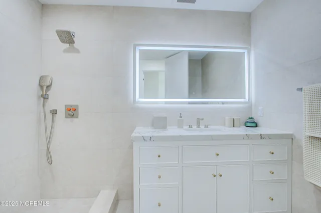 a bathroom with a sink vanity and mirror