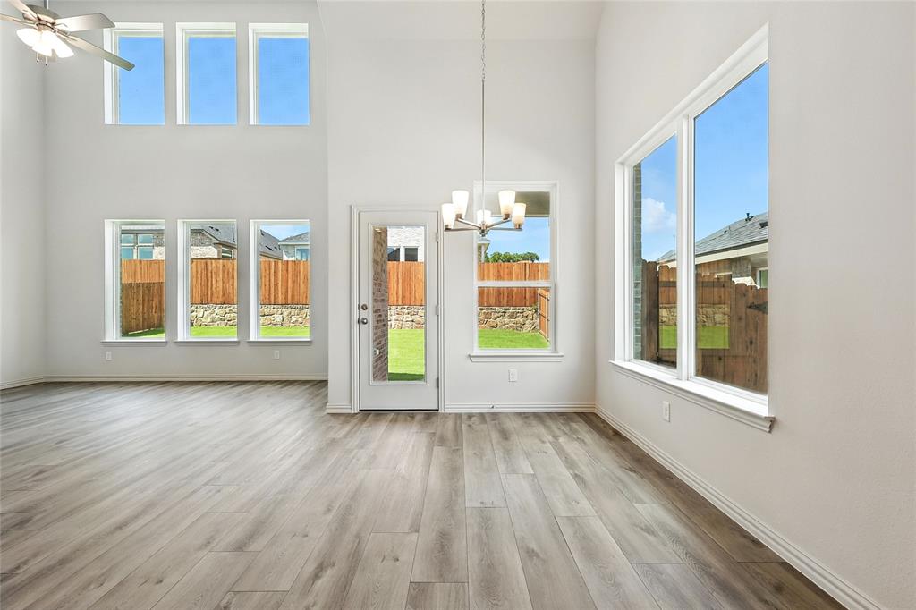 1434 Odette Drive Arlington, TX 76013 - Photo 11 of 38 Unfurnished dining area featuring a chandelier, a towering ceiling, wood finished floors, and healthy amount of natural light
