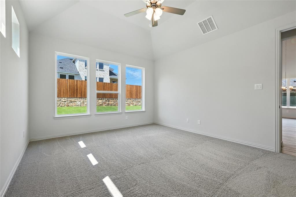 1434 Odette Drive Arlington, TX 76013 - Photo 18 of 38 Spare room featuring carpet floors, ceiling fan, and vaulted ceiling