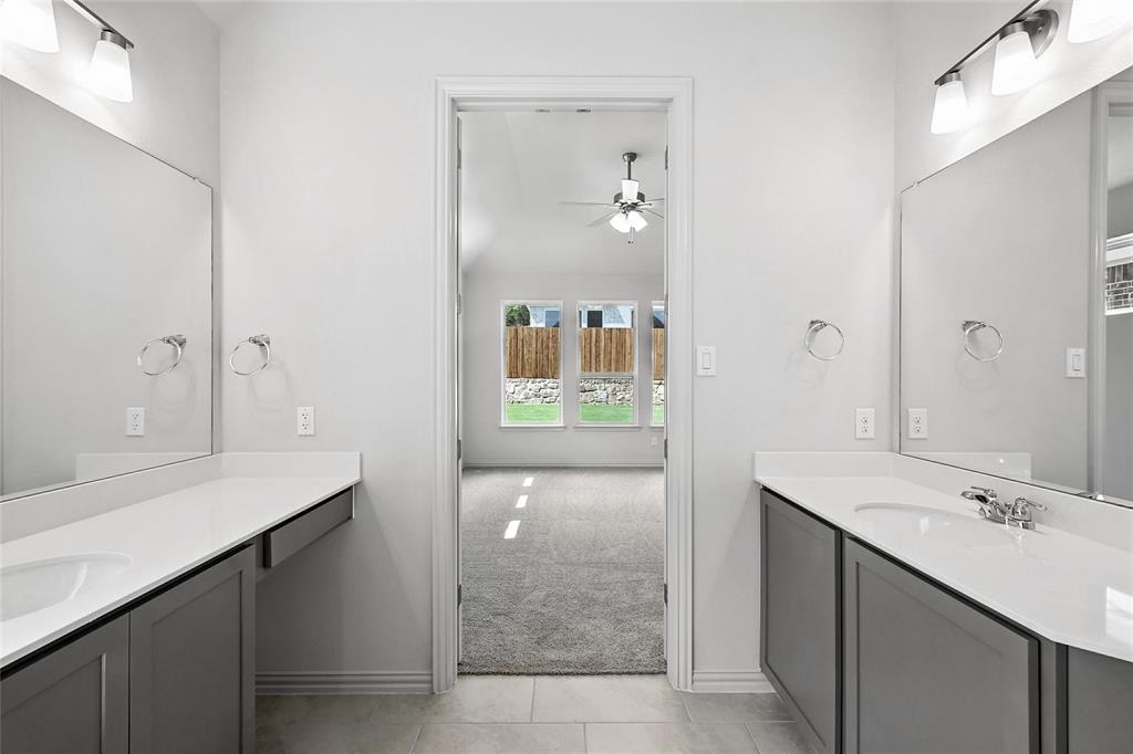 1434 Odette Drive Arlington, TX 76013 - Photo 20 of 38 Bathroom featuring ceiling fan, two vanities, tile patterned floors, and lofted ceiling