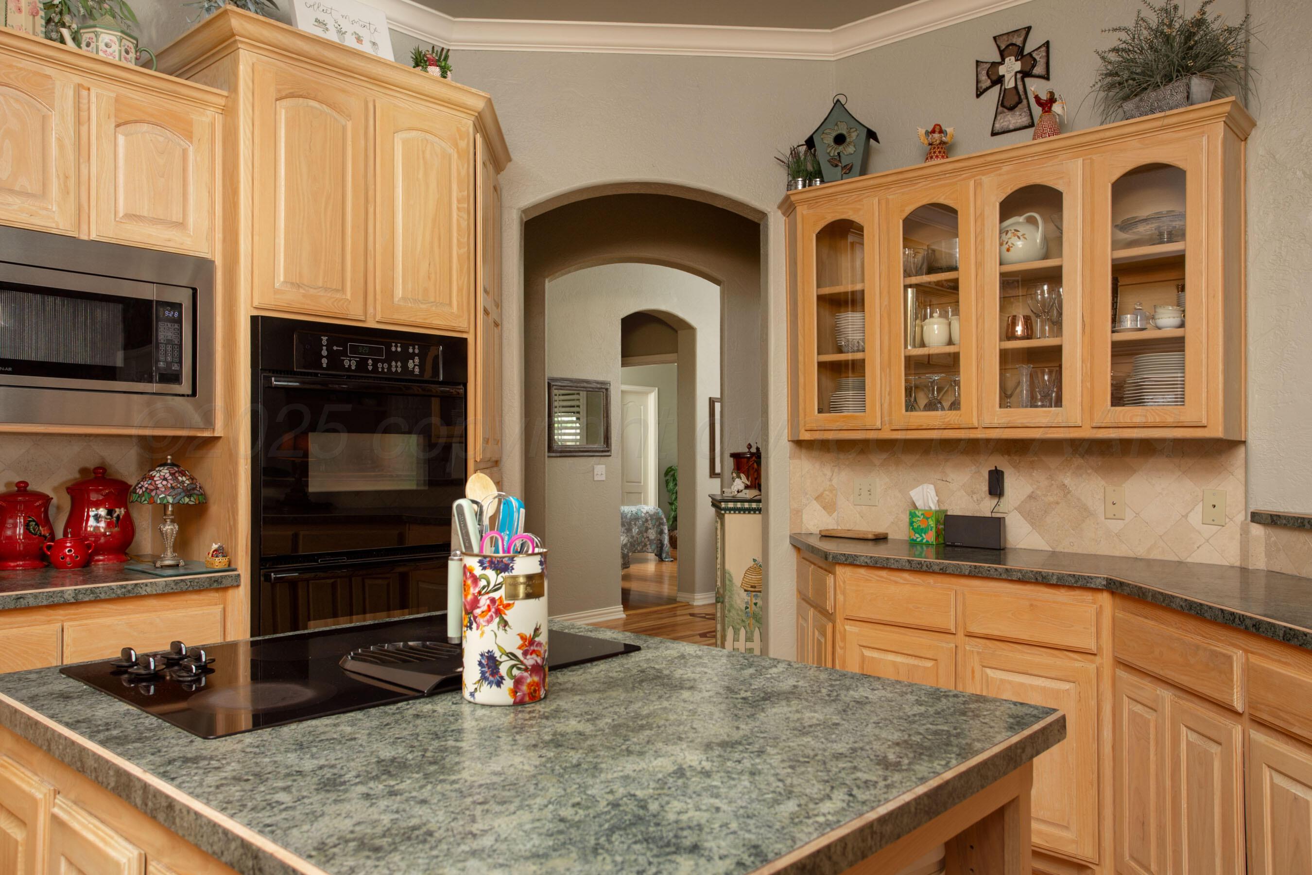 4823 Arden Road Amarillo, TX 79110 - Photo 23 of 53 a kitchen with a sink a stove and cabinets