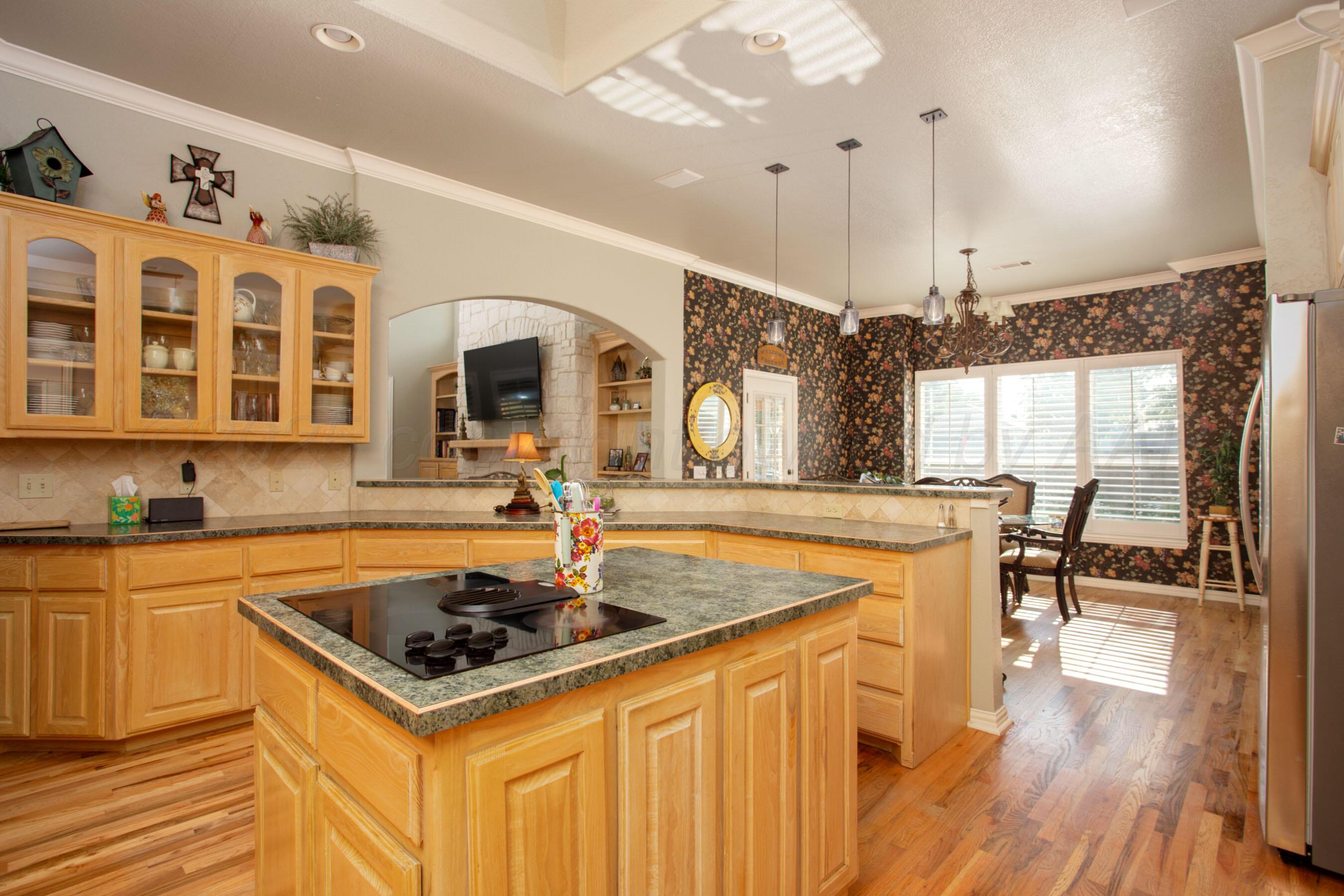4823 Arden Road Amarillo, TX 79110 - Photo 24 of 53 a kitchen with a sink a stove a dining table and chairs