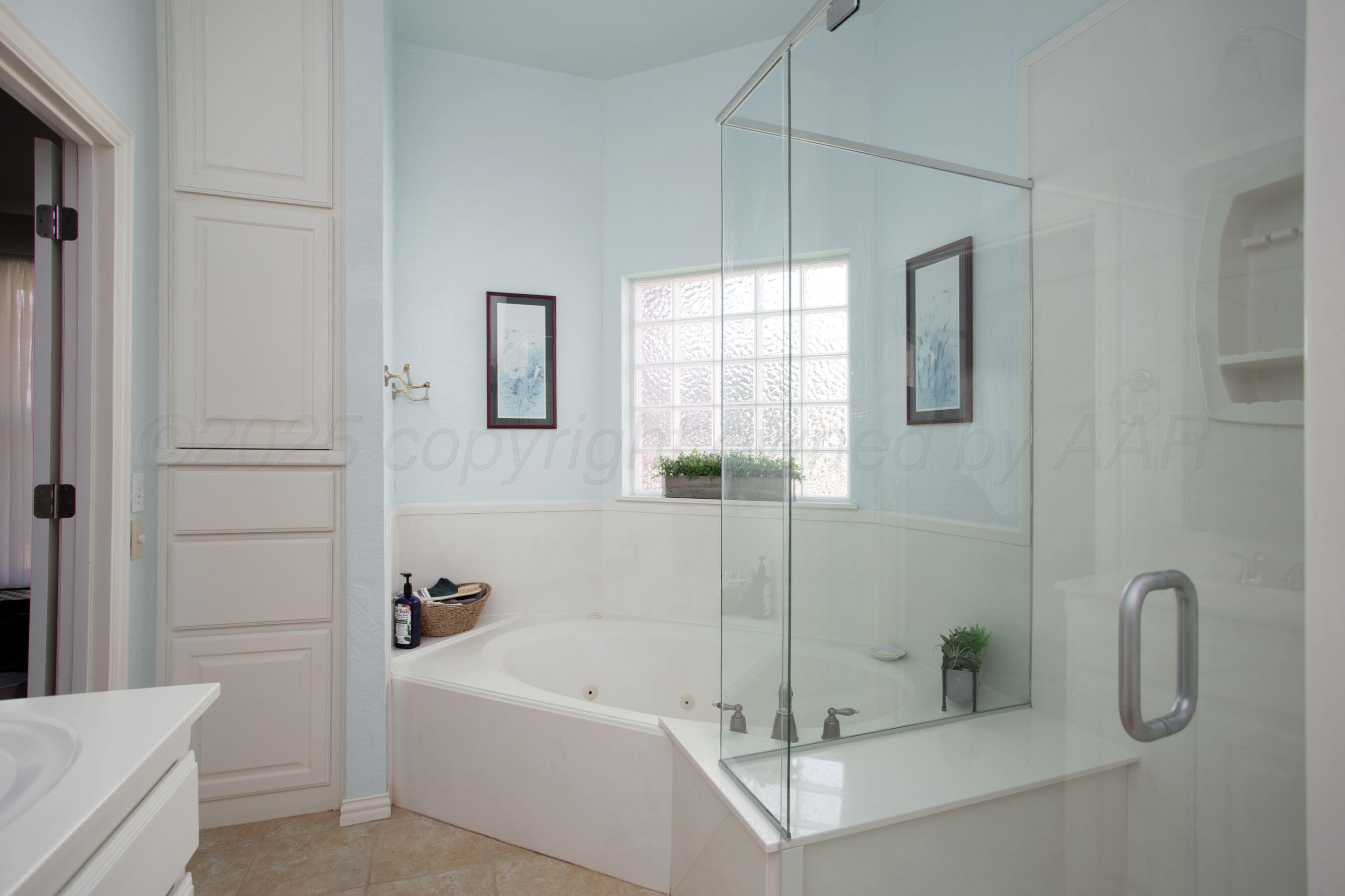 4823 Arden Road Amarillo, TX 79110 - Photo 29 of 53 a bathroom with a tub a window and a shower