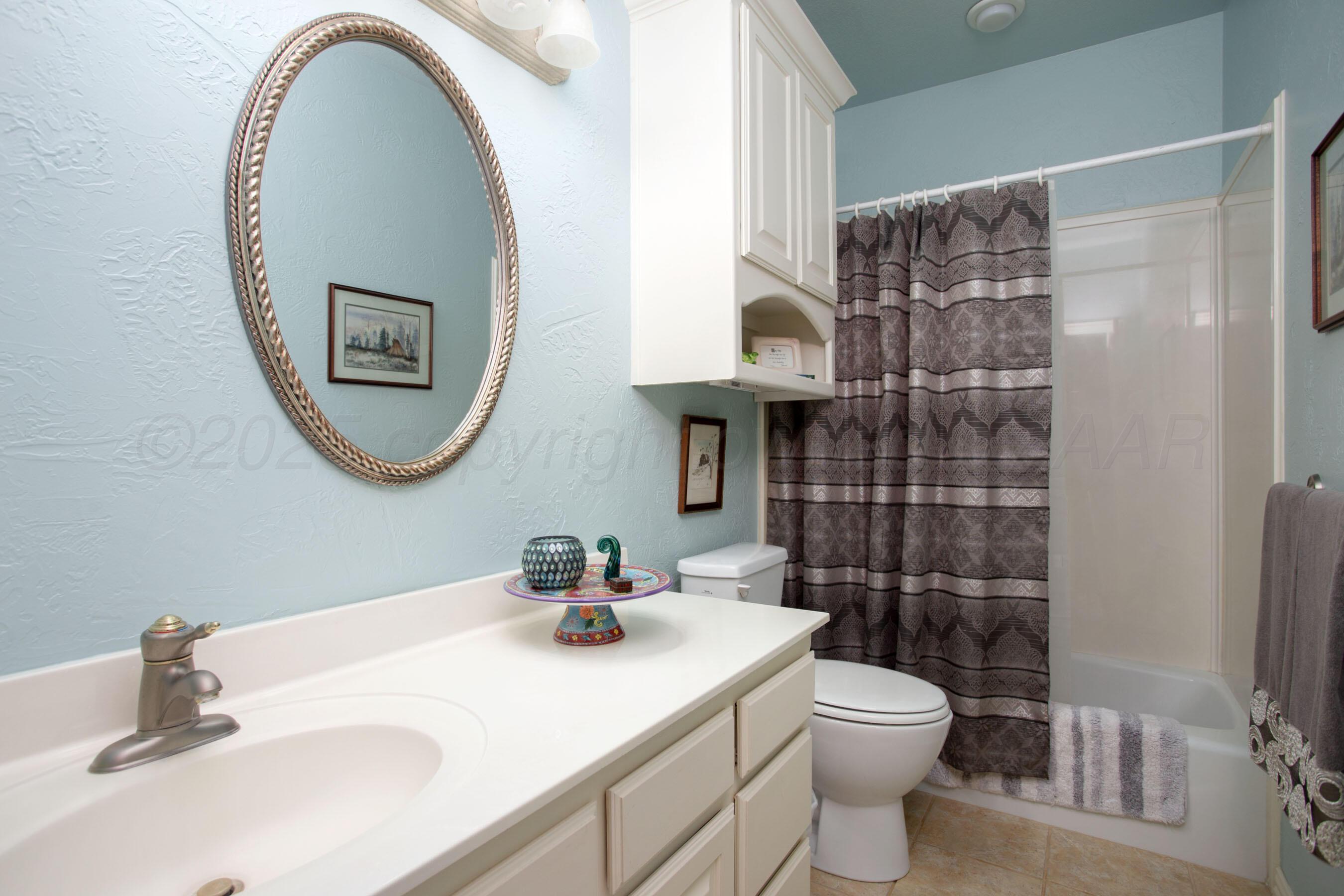 4823 Arden Road Amarillo, TX 79110 - Photo 34 of 53 a bathroom with a toilet a sink and mirror