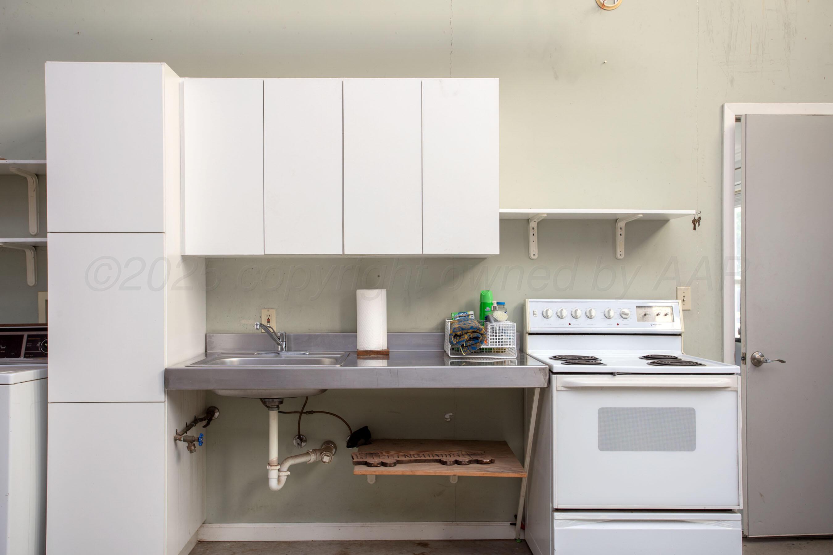 4823 Arden Road Amarillo, TX 79110 - Photo 44 of 53 a kitchen with appliances a sink and cabinets