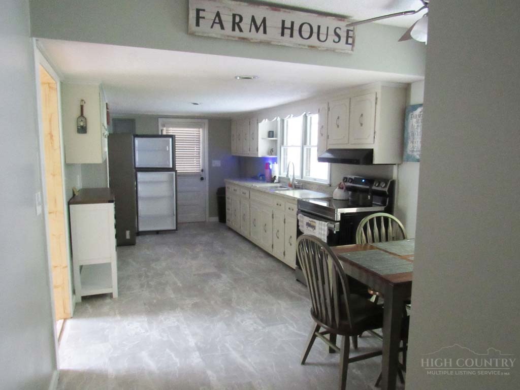 805 Ed Little Road Warrensville, NC 28693 - Photo 44 of 49 a kitchen with granite countertop a stove a sink and a refrigerator