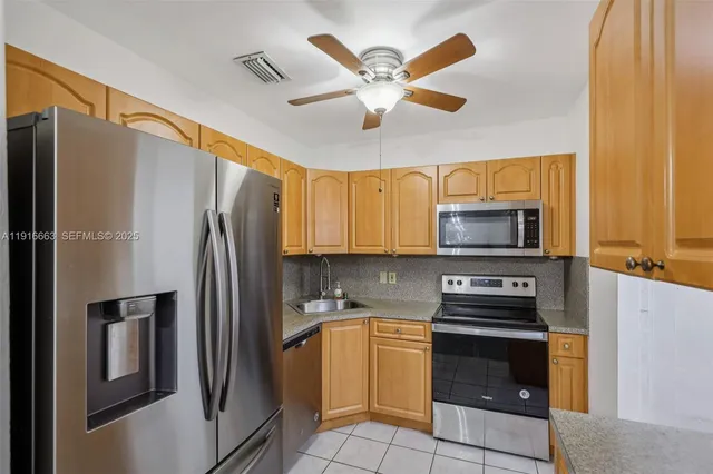 a kitchen with stainless steel appliances a refrigerator stove and microwave