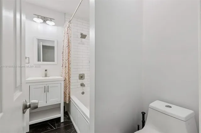 an empty room with wooden floor chandelier fan and windows