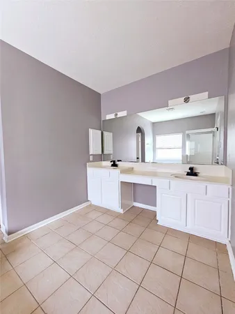 an empty room with wooden floor ceiling fan and windows
