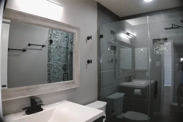 a bathroom with a toilet a sink and shower