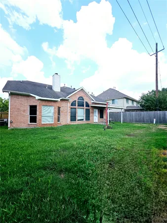 a view of a backyard with grass & fence