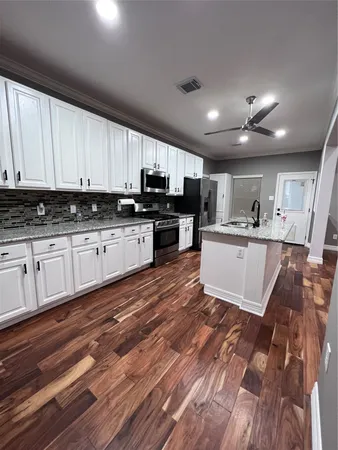 a large kitchen with stainless steel appliances granite countertop a stove a sink dishwasher and a refrigerator