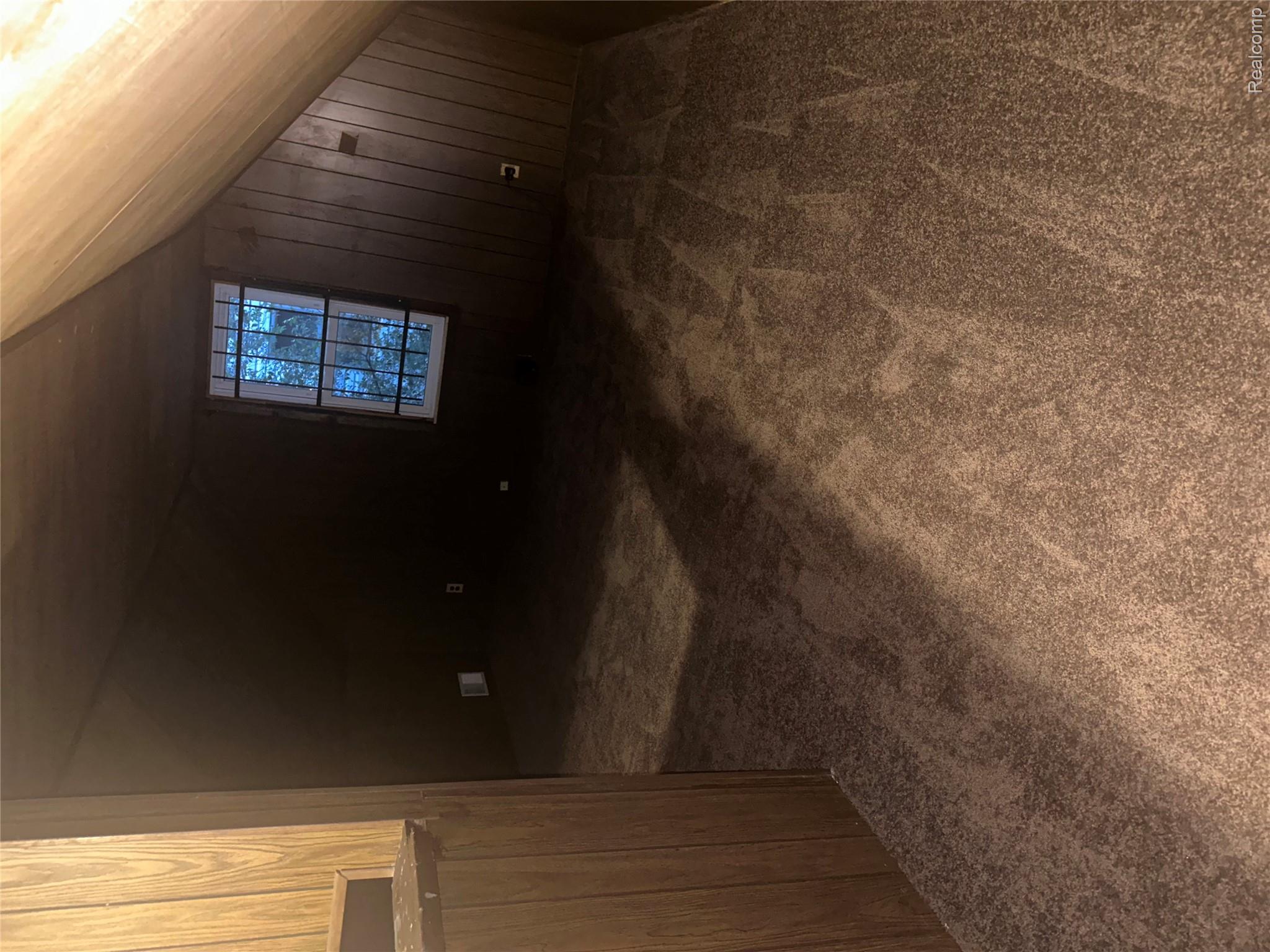 20065 Southfield Road Detroit, MI 48235 - Photo 10 of 17 Additional living space featuring dark carpet, wooden walls, and vaulted ceiling